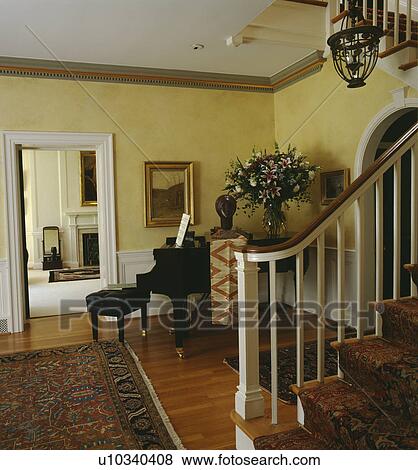 Stock Photo - Sculpture head on small grand piano in yellow hall with Regency staircase. Fotosearch