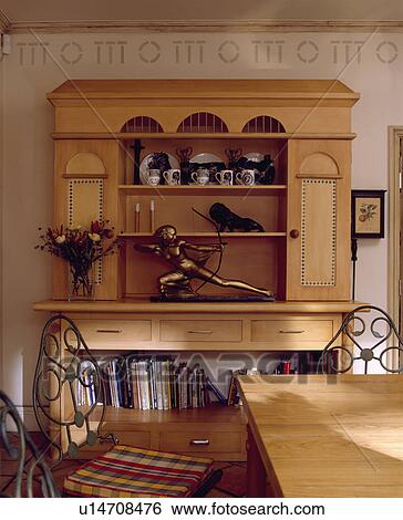 Stock Photograph - Sculpture on eighties dresser below stencil pattern on wall in neutral dining room. Fotosearch