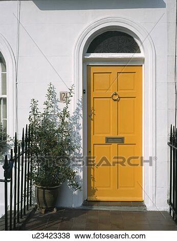 Shrub in pot beside traditional yellow front door with fanlight View Large Photo Image Stock Photo - Shrub in pot beside traditional yellow front door with fanlight. Fotosearch