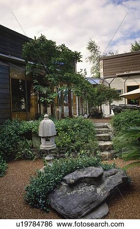 Shrubs and natural rock with stone Japanese lantern in oriental style garden in front of modern house View Large Photo Image Stock Photograph - Shrubs and natural rock with stone Japanese lantern in oriental style garden in front of modern house. Fotosearch