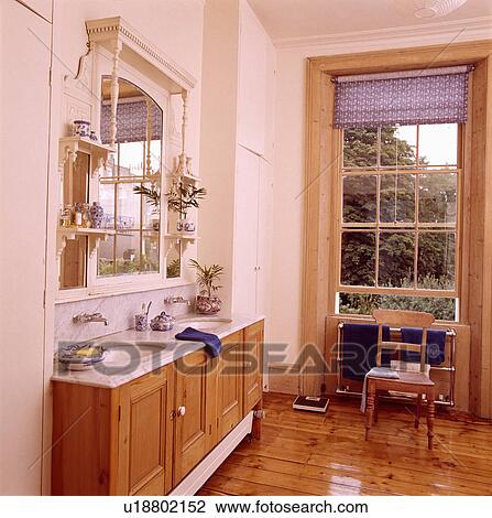 Sideways view of Edwardian overmantel mirror above pine vanity unit in bathroom with polished wooden floor View Large Photo Image Stock Image - Sideways view of Edwardian overmantel mirror above pine vanity unit in bathroom with polished wooden floor. Fotosearch