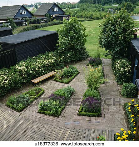 Small formal beds in paving in country garden in summer View Large Photo Image Stock Photograph - Small formal beds in paving in country garden in summer . Fotosearch