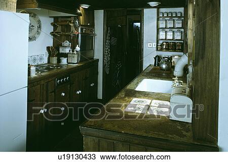 Small kitchen with tiles set into wooden worktop and hob fitted into pine cupboard  View Large Photo Image Stock Image - Small kitchen with tiles set into wooden worktop and hob fitted into pine cupboard . Fotosearch