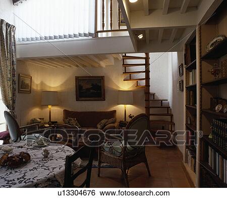 Stock Photograph - Small openplan dining and living room with staircase to mezzanine. Fotosearch