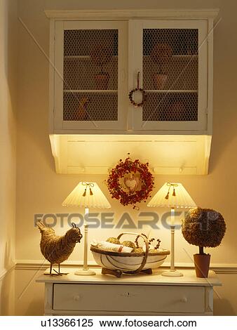 small wall cupboard above lighted lamps and dried moss tree with trug and wreath on chest of drawers View Large Photo Image Stock Photography - small wall cupboard above lighted lamps and dried moss tree with trug and wreath on chest of drawers. Fotosearch
