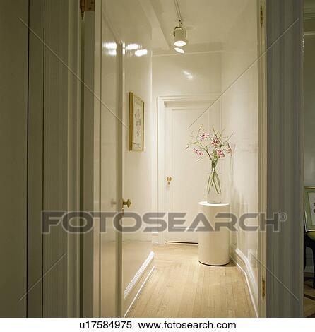 Spotlights in narrow modern whtie hall with white cylindrical table and wooden flooring View Large Photo Image Stock Photography - Spotlights in narrow modern whtie hall with white cylindrical table and wooden flooring. Fotosearch