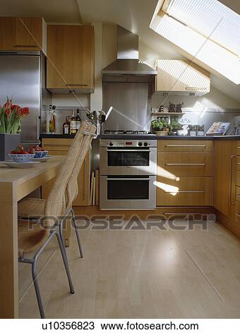Stainless steel extractor and oven in modern attic kitchen with wooden flooring View Large Photo Image Stock Image - Stainless steel extractor and oven in modern attic kitchen with wooden flooring. Fotosearch