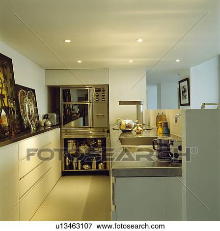 Stainless steel oven with pans stored open shelves in modern white kitchen with stainless steel worktop View Large Photo Image Stock Photo - Stainless steel oven with pans stored open shelves in modern white kitchen with stainless steel worktop. Fotosearch
