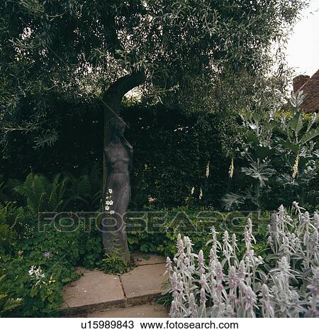 Statue below tree in country garden View Large Photo Image Stock Image - Statue below tree in country garden. Fotosearch