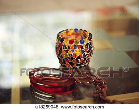 Stock Photo - Still-Life of colourful mosaic candle-holder and glass bangles. Fotosearch