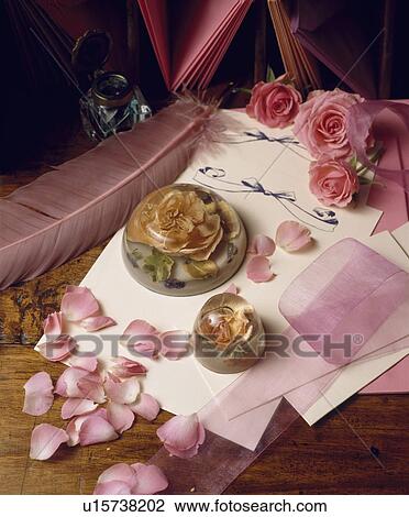 Stock Image - Still-Life of rose petals and paperweight. Fotosearch