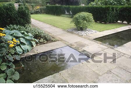 Picture - Stone paved path between two rectangular ponds in large country garden. Fotosearch