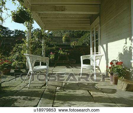 Stock Image - Stone paved veranda on traditional country house. Fotosearch