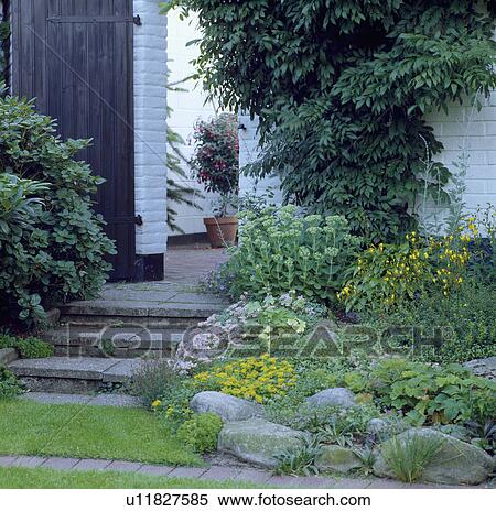Stone steps to doorway beside rockery in country garden in summer View Large Photo Image Stock Photography - Stone steps to doorway beside rockery in country garden in summer. Fotosearch