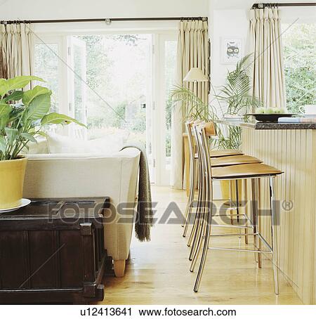 Stock Image - Stools at breakfast bar in modern living room. Fotosearch