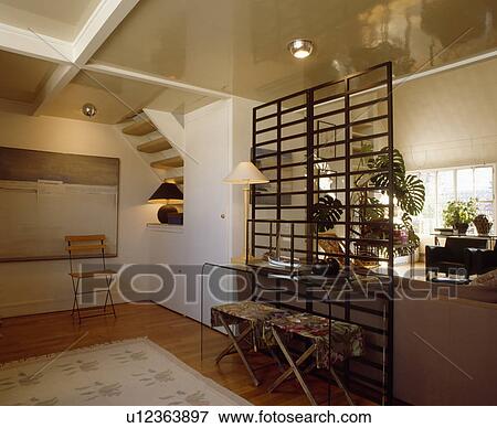 Stools below narrow perspex table beside trellis divider in eighties dining room View Large Photo Image Stock Photo - Stools below narrow perspex table beside trellis divider in eighties dining room. Fotosearch