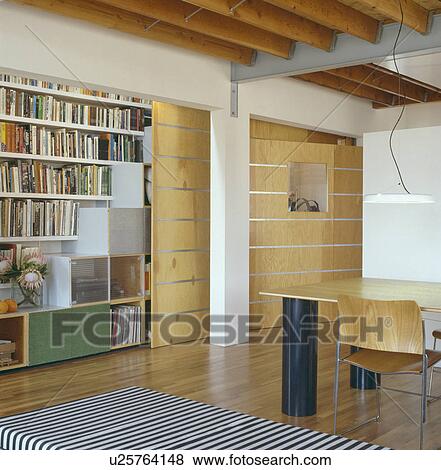 Stock Photo - Storage cubes on shelves in modern city dining room with beech wall. Fotosearch