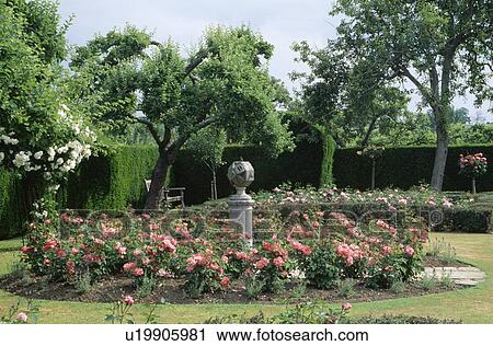 Sundial on plinth in circular bed with pink roses in large country garden View Large Photo Image Stock Image - Sundial on plinth in circular bed with pink roses in large country garden. Fotosearch