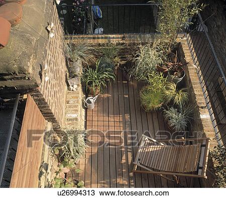 Stock Image - Sunny balcony with pots of grasses and bamboo.. Fotosearch