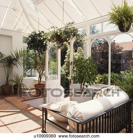 Sunny traditional styled conservatory with black and white furniture and large plants. View Large Photo Image Stock Photo - Sunny traditional styled conservatory with black and white furniture and large plants.. Fotosearch
