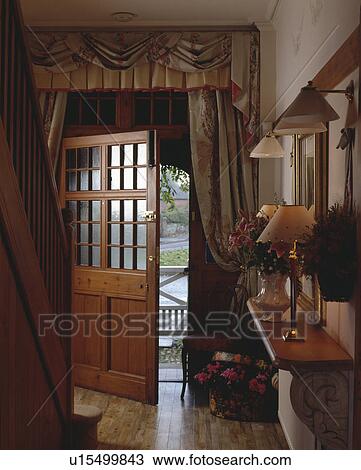 Swagged and tailed curtains above half-glazed door in traditional country hall View Large Photo Image Stock Image - Swagged and tailed curtains above half-glazed door in traditional country hall. Fotosearch