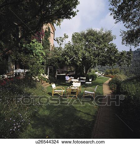 Table and chairs on lawn in country garden in summer View Large Photo Image Picture - Table and chairs on lawn in country garden in summer. Fotosearch