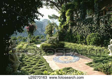 Stock Image - Terracotta paving in formal garden in southern France in summer. Fotosearch