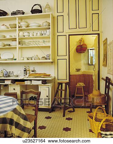 Tiled floor in French dining room with white crockery on shelves and cupboard above doorway View Large Photo Image Picture - Tiled floor in French dining room with white crockery on shelves and cupboard above doorway. Fotosearch