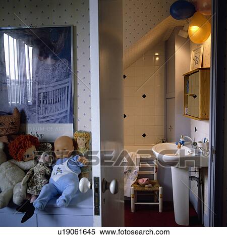 Stock Photography - Toys and dolls on chest beside open door to child's ensuite bathroom. Fotosearch