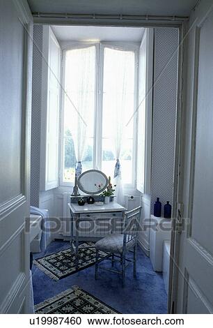 Traditional bathroom with antique chair and dressing table in front of tall windows with voile curtains and white shutters View Large Photo Image Stock Image - Traditional bathroom with antique chair and dressing table in front of tall windows with voile curtains and white shutters. Fotosearch