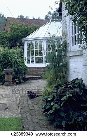 Stock Photo - Traditional country house with Victorian-style conservatory extension. Fotosearch