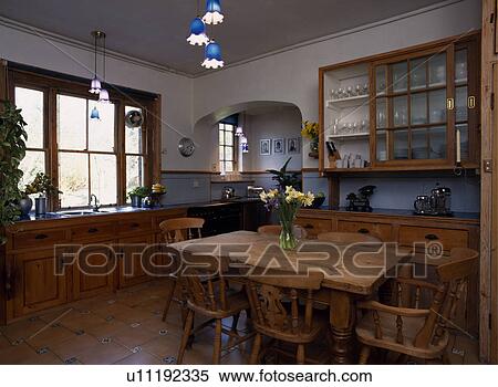Traditional old victorian or edwardian kitchen with pine table and chairs and glass fronted cupboard View Large Photo Image Stock Photography - Traditional old victorian or edwardian kitchen with pine table and chairs and glass fronted cupboard. Fotosearch