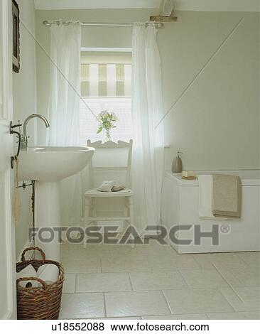 Traditional white bathroom with wicker basket and roman blind View Large Photo Image Stock Photo - Traditional white bathroom with wicker basket and roman blind . Fotosearch
