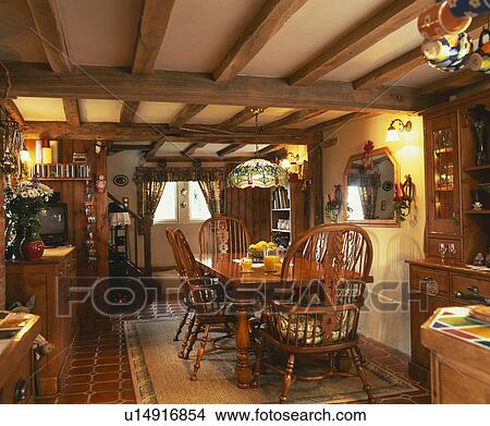 Traditional wooden beamed country kitchen with table and chairs. View Large Photo Image Picture - Traditional wooden beamed country kitchen with table and chairs.. Fotosearch