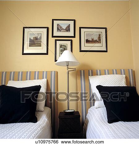 Stock Photograph - Traditional yellow bedroom with twin beds both with striped headboards . Fotosearch