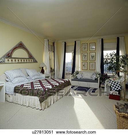 Triangular decoration above bed with patchwork quilt in city bedroom with cream carpet and curtains View Large Photo Image Stock Image - Triangular decoration above bed with patchwork quilt in city bedroom with cream carpet and curtains. Fotosearch