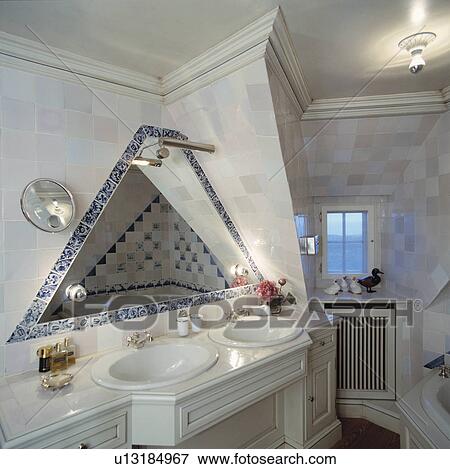 Triangular mirror above double basins in vanity unit in grey tiled bathroom with angular wall View Large Photo Image Stock Photo - Triangular mirror above double basins in vanity unit in grey tiled bathroom with angular wall. Fotosearch