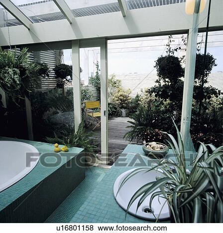 Turquoise mosaic tiles in modern bathroom extension with open patio doors to small courtyard garden View Large Photo Image Stock Photo - Turquoise mosaic tiles in modern bathroom extension with open patio doors to small courtyard garden. Fotosearch