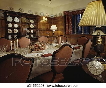 Upholstered pink chairs and lighted lamps in panelled hotel dining room View Large Photo Image Stock Photo - Upholstered pink chairs and lighted lamps in panelled hotel dining room. Fotosearch