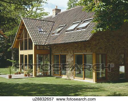 Stock Photo - velux windows and sliding glass doors on modern country house with reclaimed pantiles . Fotosearch