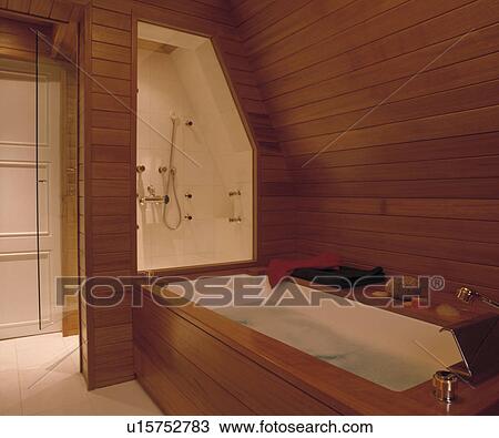 White bath and seperate shower in modern panelled attic bathroom View Large Photo Image Stock Image - White bath and seperate shower in modern panelled attic bathroom. Fotosearch