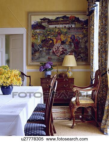 Stock Photography - White cloth on rectangular table in yellow dining room with large picture on the wall. Fotosearch