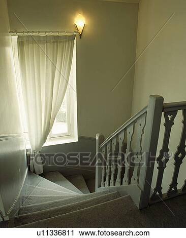 White curtain and wall-light above staircase with grey wooden bannisters and grey carpet View Large Photo Image Stock Image - White curtain and wall-light above staircase with grey wooden bannisters and grey carpet. Fotosearch