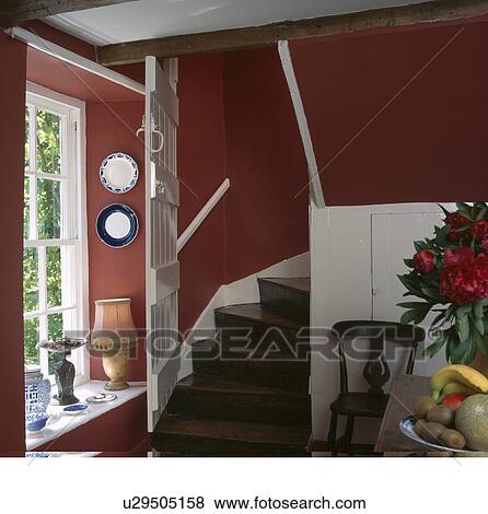 White door open on oak staircase in red cottage hall dining room View Large Photo Image Stock Photo - White door open on oak staircase in red cottage hall dining room. Fotosearch