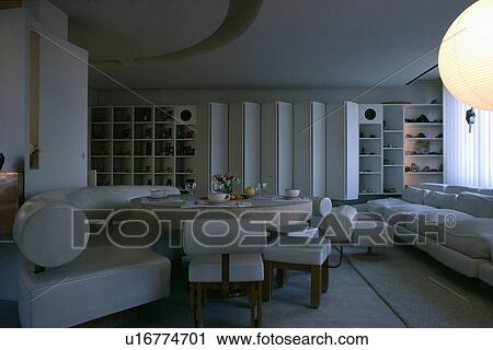 White leather banquette seating around circular table in white living room with white sofa and folding screen View Large Photo Image Stock Image - White leather banquette seating around circular table in white living room with white sofa and folding screen. Fotosearch