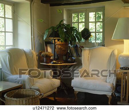 White loosecovers on armchairs in traditional living room View Large Photo Image Stock Image - White loosecovers on armchairs in traditional living room. Fotosearch