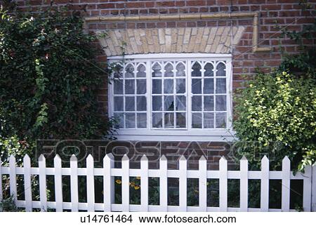 White picket fence in front of cottage with white painted window View Large Photo Image Picture - White picket fence in front of cottage with white painted window. Fotosearch