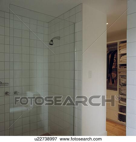 Stock Photo - White tiled architectural shower room leading to dressingroom.. Fotosearch