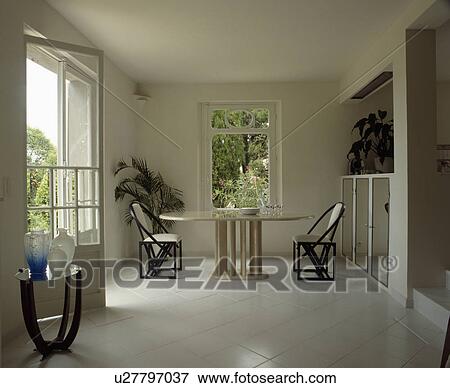 Picture Of White Tiled Floor In Uncluttered Dining Room With Picture White Tiled Floor In Uncluttered Dining Room With Oval Table And Black Chairs