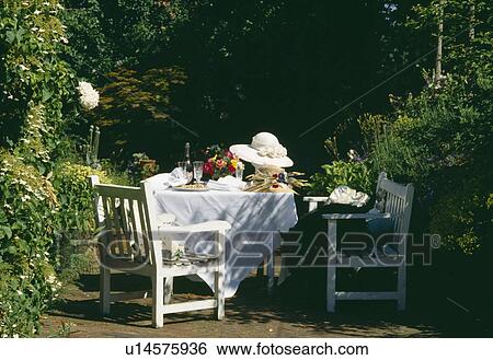 White wooden furniture and white cloth on table with straw hats and champagne in country garden View Large Photo Image Stock Photograph - White wooden furniture and white cloth on table with straw hats and champagne in country garden. Fotosearch
